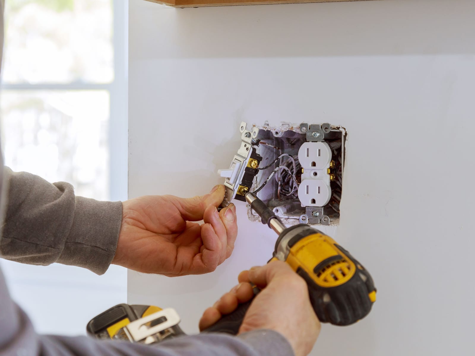 Installing a new light switch and receptacle in a finished wall during a renovation
